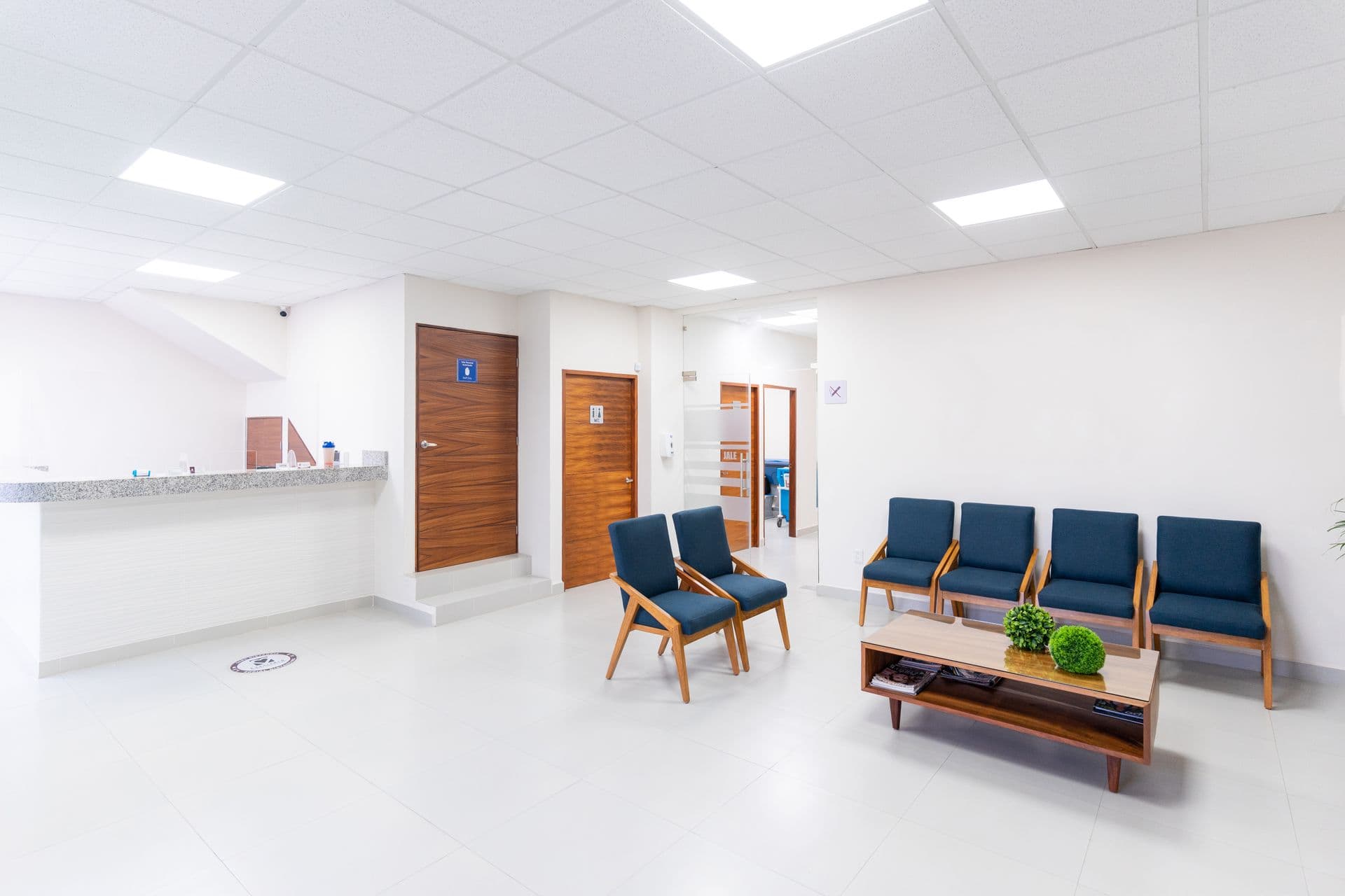 Bright clinic reception area with front desk and waiting chairs