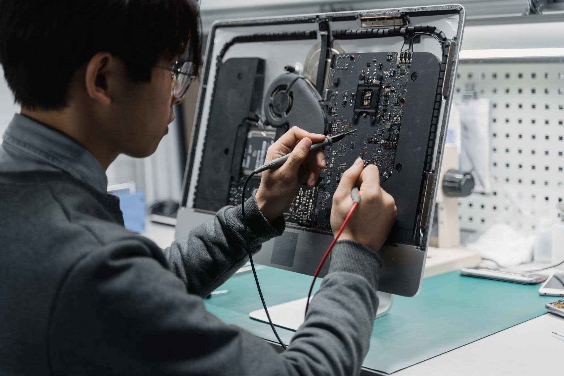 Technician repairing a computer at a workbench